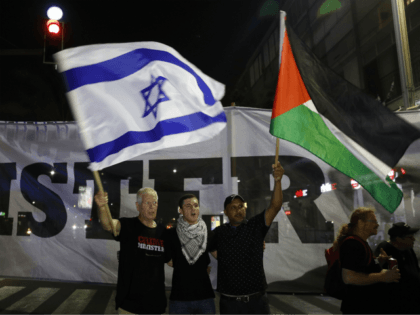 Arab Israelis and their supporters carry a Palestinian (R) and an Israeli flag during a demonstration to protest against the 'Jewish Nation-State Law' in the Israeli coastal city of Tel Aviv on August 11, 2018. The banner in Arabic and Hebrew reads 'justice'. - The controversial law passed last month …
