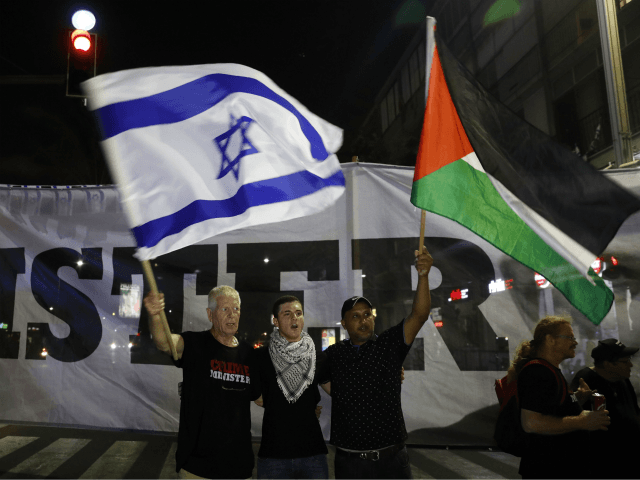 Arab Israelis and their supporters carry a Palestinian (R) and an Israeli flag during a de