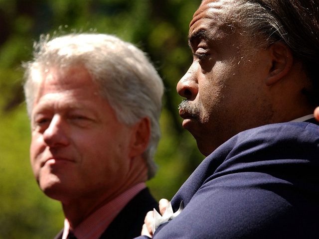 Former U.S. President Bill Clinton (L) stands with Reverend Al Sharpton at a voter registr