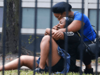 Chicago_Violence In this Sunday, Aug. 5, 2018 photo, two women cry outside the Stroger Hospital in Chicago after they were asked to leave due to overwhelming crowds of family and friends of shooting victims. Police Superintendent Eddie Johnson plans to discuss the weekend violence during a Monday news conference. (Antonio Perez/Chicago …