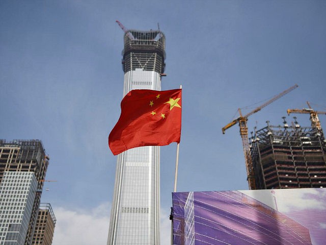 A Chinese national flag flies at the construction site for new buildings in Beijing's cent