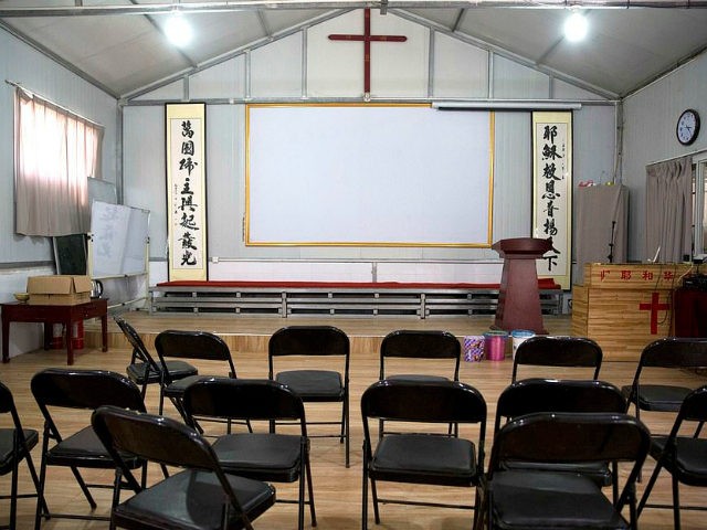 In this photo taken Monday, June 4, 2018, Chinese calligraphy which reads "All nations belong to the Lord arising to shine" at left and "Jesus's salvation spreads to the whole world" at right are displayed below a crucifix in a house church shut down by authorities near the city of …