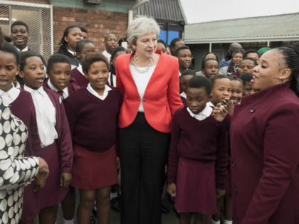 Britain's Prime Minister Theresa May poses with school children during a visit to the ID Mkhize Secondary School in Gugulethu, as part of a working visit to South Africa, on August 28, 2018, about 15km from the centre of Cape Town. (Photo by Rodger BOSCH / POOL / AFP) (Photo …