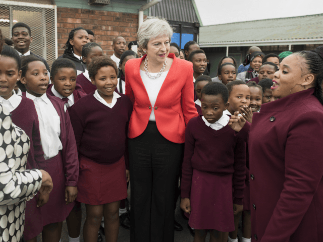 Britain's Prime Minister Theresa May poses with school children during a visit to the ID M
