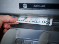 GettyImages-135286797 A man withdraws Swedish Crowns currency banknotes from an ATM machine in Stockholm on December 8, 2011 in Stockholm. AFP PHOTO / JONATHAN NACKSTRAND (Photo credit should read JONATHAN NACKSTRAND/AFP/Getty Images)