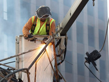LOS ANGELES, CA - DECEMBER 8: A worker uses a torch to clear debris from the 110 freeway a