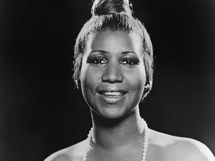 Portrait of American soul singer Aretha Franklin as she wears a strapless dress and pearl