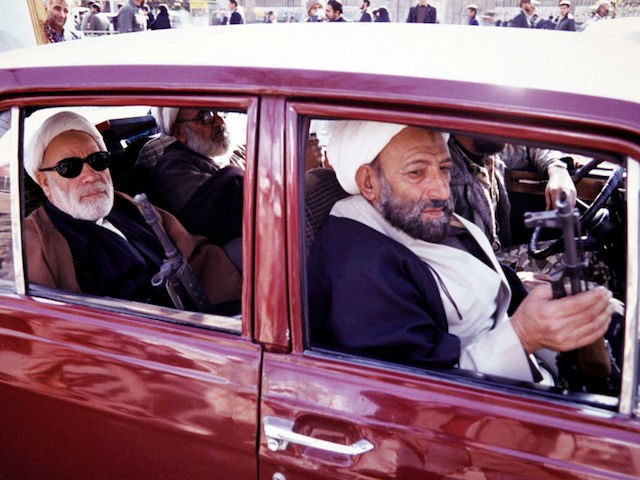 Photo taken in June 1988 in Qom shows armed Mullahs driving in car. / AFP PHOTO / -
