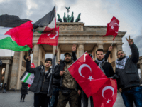 GettyImages-888378020 Demonstrators wave Palestinian and Turkish flags in front of the Brandenburg Gate, next to the US embassy in Berlin on December 8, 2017, following US President Donald Trump's decision to recognise Jerusalem as the capital of the Israeli state. / AFP PHOTO / John MACDOUGALL (Photo credit should read JOHN …