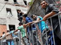 Migrant men wait in line for their lunch in front of an abandoned school dorm, near the center of the western-Bosnian town of Bihac, on July 4, 2018. (Photo by ELVIS BARUKCIC / AFP) (Photo credit should read ELVIS BARUKCIC/AFP/Getty Images)
