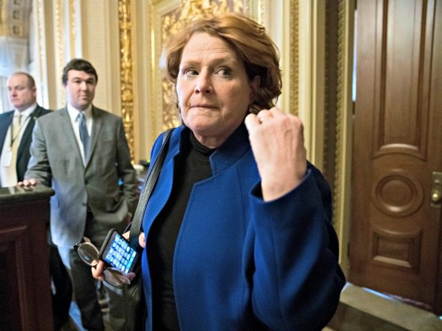 In this Jan. 22, 2018 file photo, Sen. Heidi Heitkamp, D-N.D., leaves a meeting with fellow Democrats at the Capitol in Washington. In places like Boston and Los Angeles, Democrats are blasting the new tax law as a boon to the rich and a corporate giveaway. In North Dakota, Sen. …