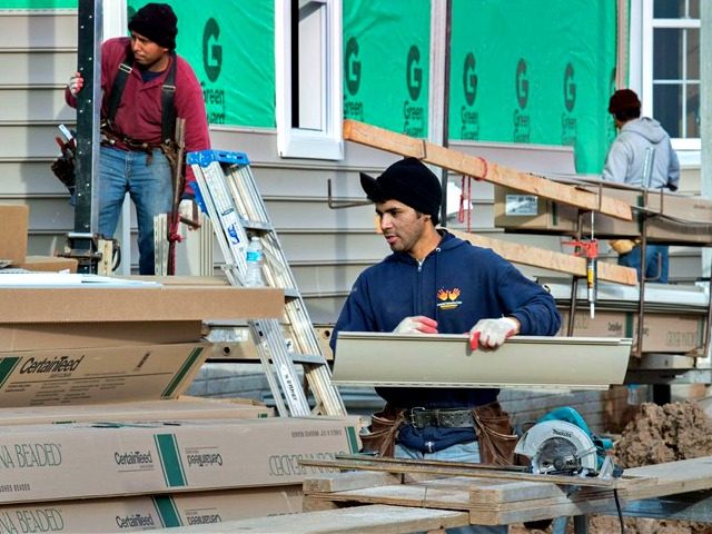 Construction workers install exterior beaded vinyl siding to a new home in Ashburn, Virgin