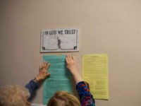 In-God-We-Trust-sign-wall-ladies-hands-getty Election officials affix voting notices to the wall, below a plaque that states 'IN GOD WE TRUST,' at the Hazleton City Hall polling station before voters arrive for the 2018 Pennsylvania Primary Election on May 15, 2018 in Hazleton, Pennsylvania. In the second major May primary day nationwide, four states …