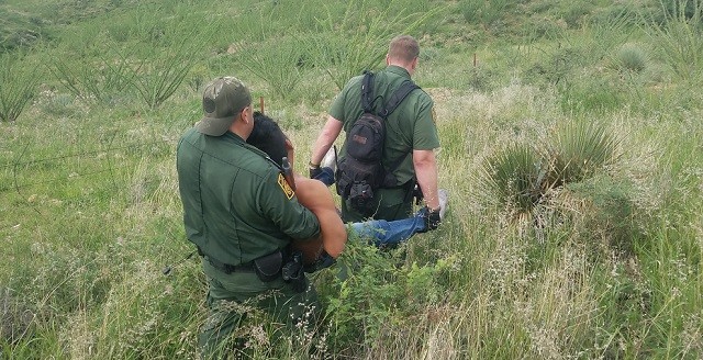 Border Patrol agents carry unconscious Mexican migrant through rough terrain to an awaiting helicopter. (Photo: U.S. Border Patrol/Tucson Sector)
