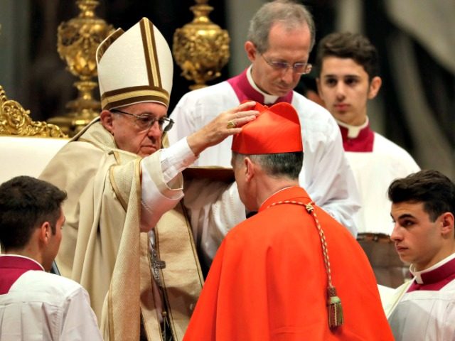 New Cardinal Blase Cupich receives the red three-cornered biretta hat during a consistory inside the St. Peter's Basilica at the Vatican on Saturday.