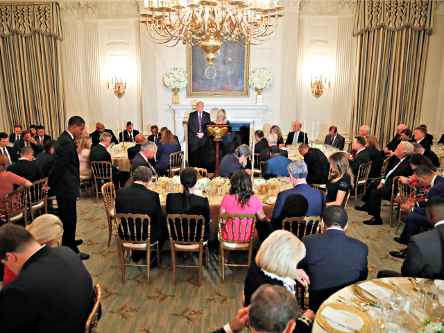 President Donald Trump bows his head in prayer as pastor Paula White leads the room in prayer during a dinner for evangelical leaders in the State Dining Room of the White House, Monday, Aug. 27, 2018, in Washington.