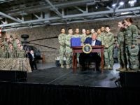 President Donald Trump signs a $716 billion defense policy bill named for Sen. John McCain Monday, Aug. 13, 2018, in Fort Drum, N.Y.