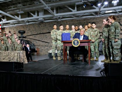 President Donald Trump signs a $716 billion defense policy bill named for Sen. John McCain Monday, Aug. 13, 2018, in Fort Drum, N.Y.