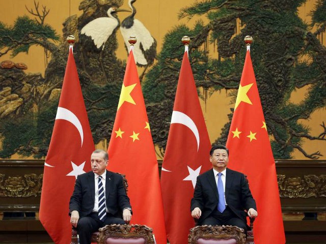 Turkish President Recep Tayyip Erdogan (L) and Chinese President Xi Jinping attend a signi