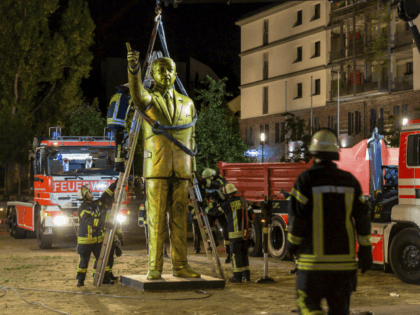 In this Aug. 28, 2018 photo a crane of the firebrigade lifts a statue of Turkish President Recep Tayyip Erdogan in Wiesbaden, western Germany. The statue was part of a controversial art project of the Wiesbaden Biennale. (Sebastian Stenzel/Wiesbaden112.de/dpa via AP)