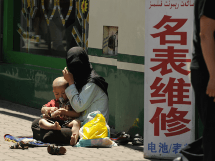 A Muslim ethnic Uighur woman begs with her baby on a street in Urumqi, capital of China's Xinjiang region on July 2, 2010 ahead of the first anniversary of bloody violence that erupted between the region's Uighurs and members of China's majority Han ethnicity. The government says nearly 200 people …