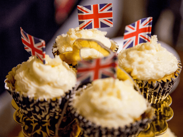 Elderflower cupcakes decorated with the Union Jack are served while a group of women watch