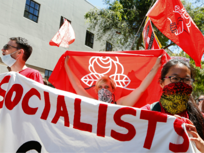 Democratic Socialists of America counter protesters hold signs and flags as they march, protesting an alt-right rally on August 5, 2018 in downtown Berkeley, California.. (Photo by Amy Osborne / AFP) (Photo credit should read AMY OSBORNE/AFP/Getty Images)