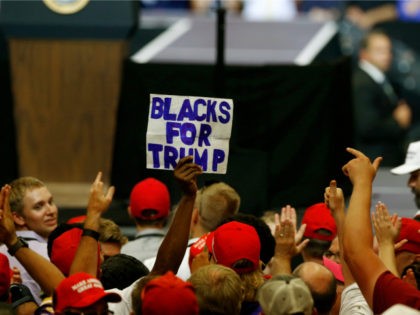 A man raises a sign "Blacks For Trump" as President Donald Trump speaks at a campaign rally Wednesday, June 27, 2018, in Fargo, N.D. (AP Photo/Jim Mone)