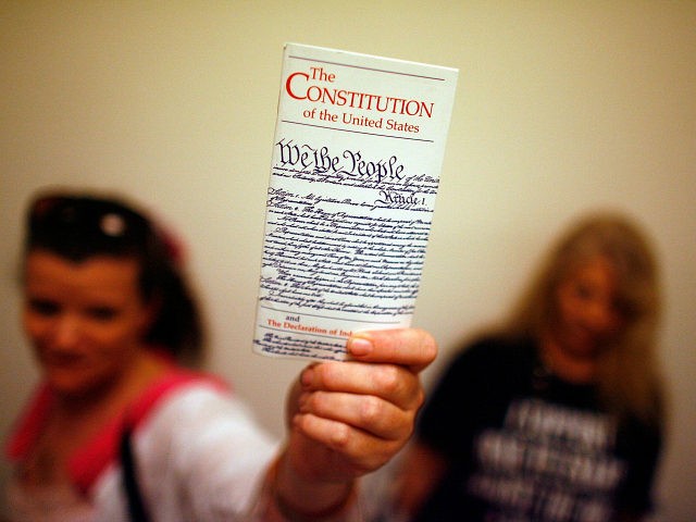 WASHINGTON - JULY 25: Elementary school teacher Lisa Petry of Virginia Beach, Virginia, holds up a copy of the U.S. Constitution while waiting in line to attend the House Judiciary Committee's hearing on the 'Executive Power and Its Constitutional Limitations' at the Rayburn House Office Building on Capitol Hill July …