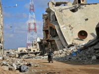 daraa A Syrian man rides his motorcycle past damaged buildings in the southern city of Daraa, on March 16, 2017. Daraa province, the cradle of the 2011 uprising against President Bashar al-Assad's regime, is mostly held by the rebels but pro-government forces and Islamic State are also present. / AFP PHOTO …
