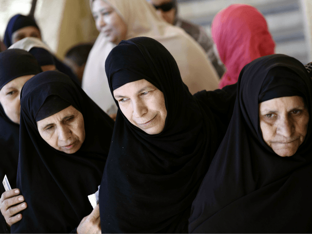 Egyptian women queue at a polling station during the second round of a referendum on a new