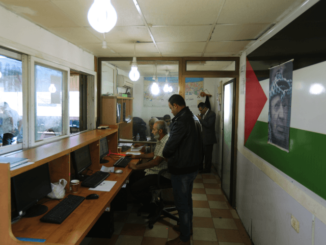 Palestinian men work at a passport control station held by the Palestinian Authority at th