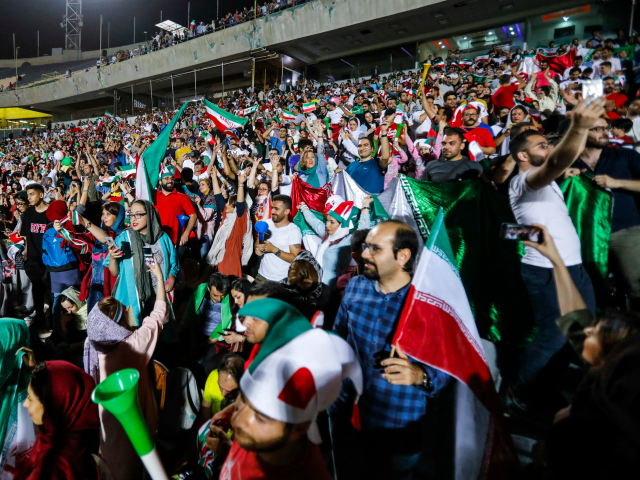 Iranian football supporters cheer for their national team during a screening of the Russia