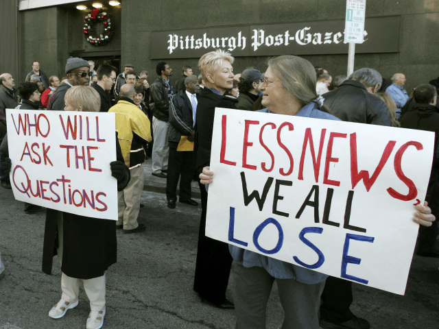 Newsroom employees hold signs outside the Pittsburgh Post Gazette building as they hold an