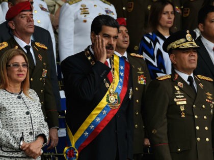 Venezuelan President Nicolas Maduro (C) gestures between his wife Cilia Flores (L) and Def