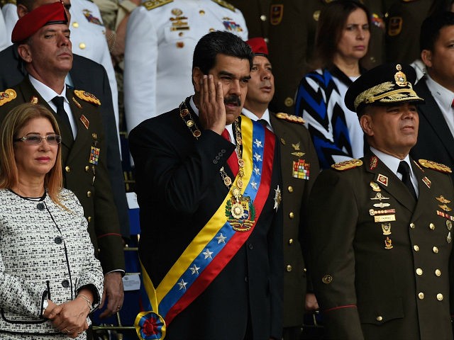 Venezuelan President Nicolas Maduro (C) gestures between his wife Cilia Flores (L) and Def