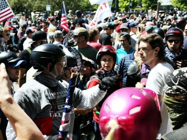 An alt-right sympathizer (L) knocks the hat off an opponents head as alt-right activists, anti-fascist protestors, and people on all sides of the political spectrum gather for a campaign rally organized by right-wing organizer, Patriot Prayer founder and Republican Senate candidate Joey Gibson in Portland, Oregon, August 4, 2018. - …