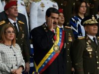 Venezuelan President Nicolas Maduro (C) gestures between his wife Cilia Flores (L) and Defence Minister General Vladimir Padrino during a ceremony to honor the National Guard in Caracas Venezuelan President Nicolas Maduro (C) gestures between his wife Cilia Flores (L) and Defence Minister General Vladimir Padrino during a ceremony to honor the National Guard in Caracas