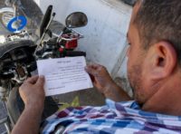 A man holds a leaflet stamped with the government forces' seal and dropped by helicopters over the northwestern Syrian town of Binnish warning of an impending assault on Idlib province and urging surrender A man holds a leaflet stamped with the government forces' seal and dropped by helicopters over the northwestern Syrian town of Binnish warning of an impending assault on Idlib province and urging surrender