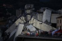 Rescuers scour through the wreckage overnight after a vast span of the Morandi bridge collapsed during a heavy rainstorm in Genoa