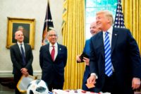 US President Donald Trump (R) jokes with a red card presented to him by FIFA President Gianni Infantino (2nd R) during a meeting in the Oval Office of the White House in Washington, DC on August 28, 2018. Looking on from left are: FIFA's Mattias Grafstrom and US Soccer Federation …