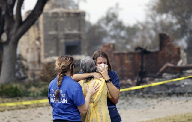 California Wildfires A resident, in yellow, wishing not to be identified, is comforted after seeing her fire ravaged home for the first time Thursday, Aug. 2, 2018, in Redding, Calif. (AP Photo/Marcio Jose Sanchez) The Associated Press