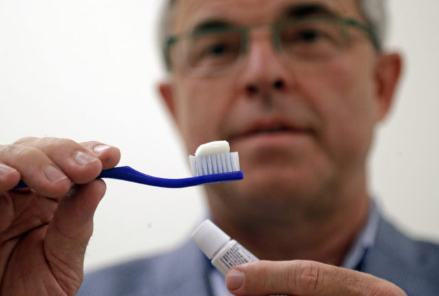 Toothbrushing Cavities Philippe Hujoel In this photo taken Friday, Aug. 3, 2018, Philippe Hujoel, a dentist and University of Washington professor, holds a toothbrush and toothpaste as he poses for a photo in an office at the school in Seattle. Dental health experts worry that more people are using toothpaste that skips the most important ingredient the fluoride and leaves them at a greater risk of cavities. (AP Photo/Elaine Thompson) The Associated Press