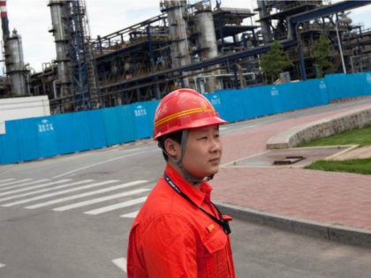 A worker at the China Petroleum & Chemical Corp. (Sinopec) Yanshan refinery escorts journa
