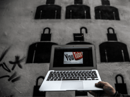 A laptop computer showing Youtube's logo on its screen is held in front of graffiti on March 27, 2014 in Istanbul. Turkey on March 27 banned video-sharing website YouTube, a week after blocking access to Twitter, after both were used to spread audio recordings implicating the prime minister in corruption, …