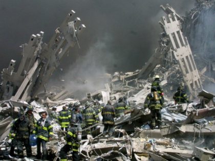 In this Sept. 11, 2001 file photo, firefighters make their way through the rubble after tw