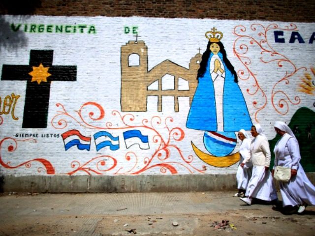 BUENOS AIRES, ARGENTINA - MARCH 17: Nun walk past a mural near the Virgin of the Miracles