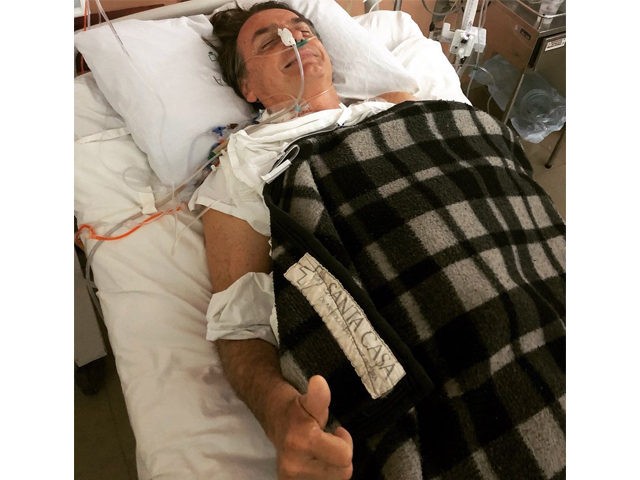 Brazilian conservative presidential candidate Jair Bolsonaro gives supporters a thumbs-up from a hospital in Sao Paulo after being stabbed at a rally, September 6, 2018