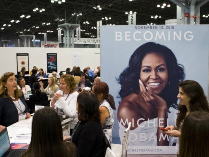 A poster for former first lady Michelle Obama's memoir, Becoming, is displayed in the Penguin Random House exhibit, Thursday, May 31, 2018 at Book Expo in New York. the book will be available in November. (AP Photo/Mark Lennihan)