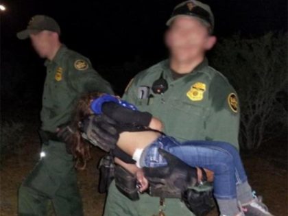 A Zapata Station Border Patrol agent carries a three-year-old girl to safety after her mot